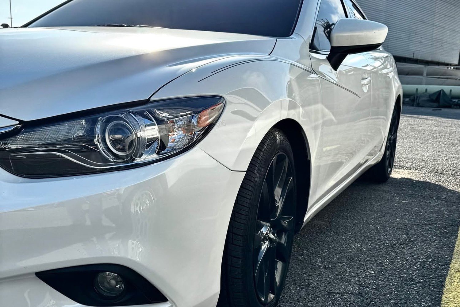 White Mazda sedan after collision repair at Lankford Paint & Body, with the front fender, headlight and bumper restored
