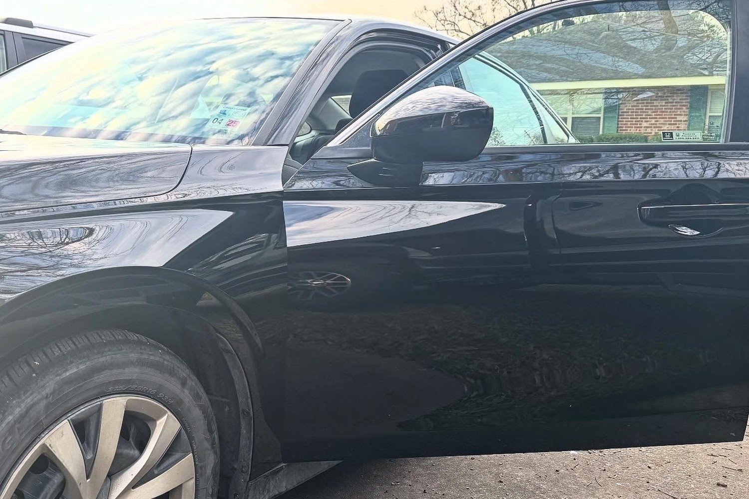 Driver side door and fender of a black Honda sedan in deep gloss after paint refinishing at Lankford Paint & Body